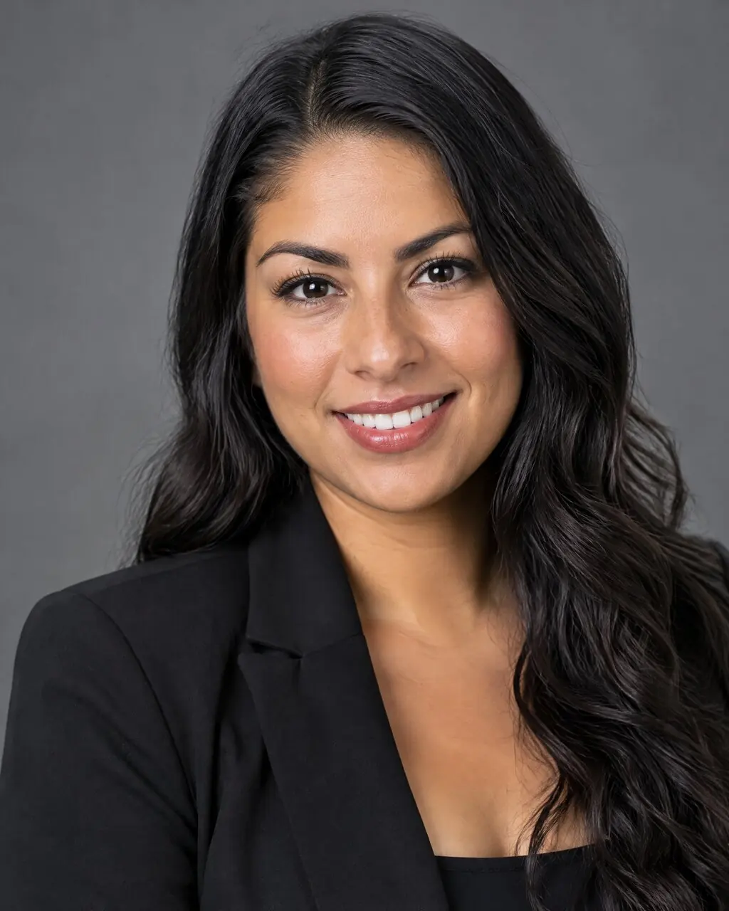 Foto profesional de mujer con blazer negro sobre fondo gris