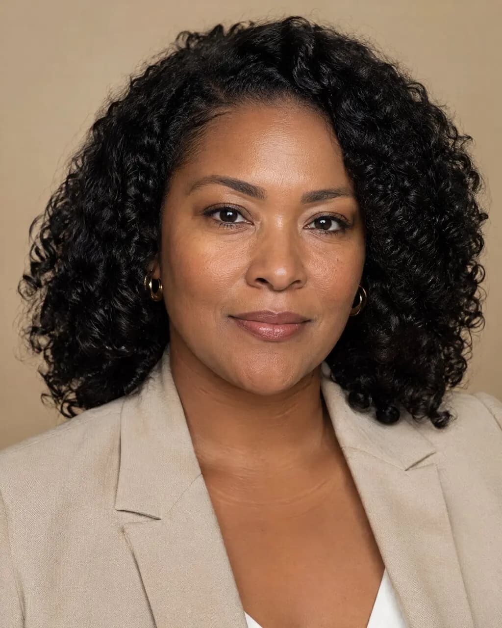 Foto para currículum de mujer con blazer beige y fondo claro