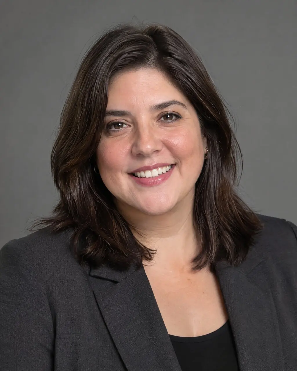Foto para CV de mujer de pelo rizado con blazer gris
