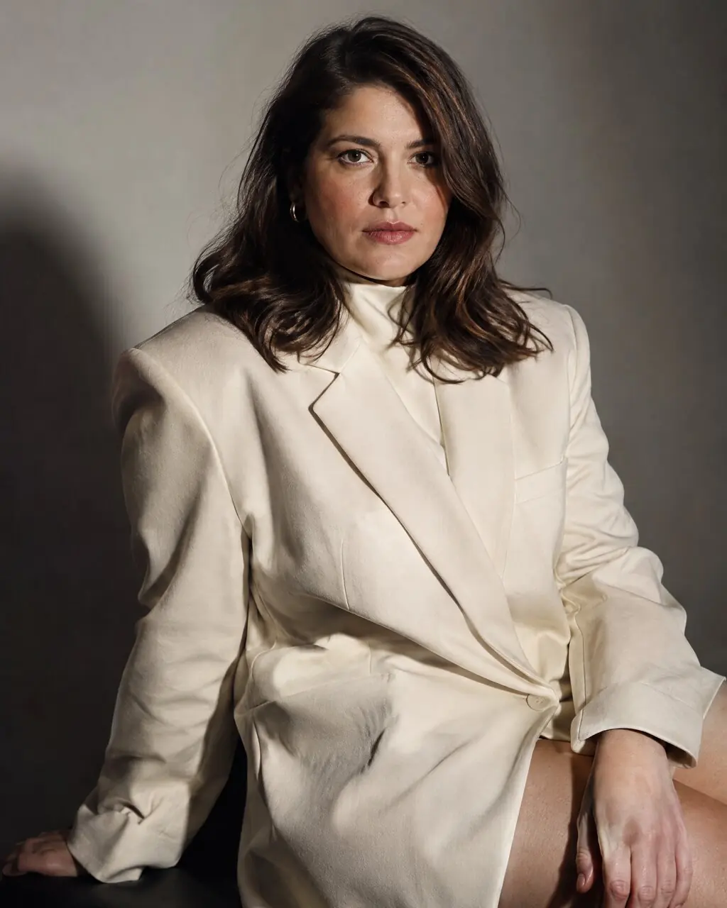 Foto editorial de mujer con blazer oversize y fondo minimalista