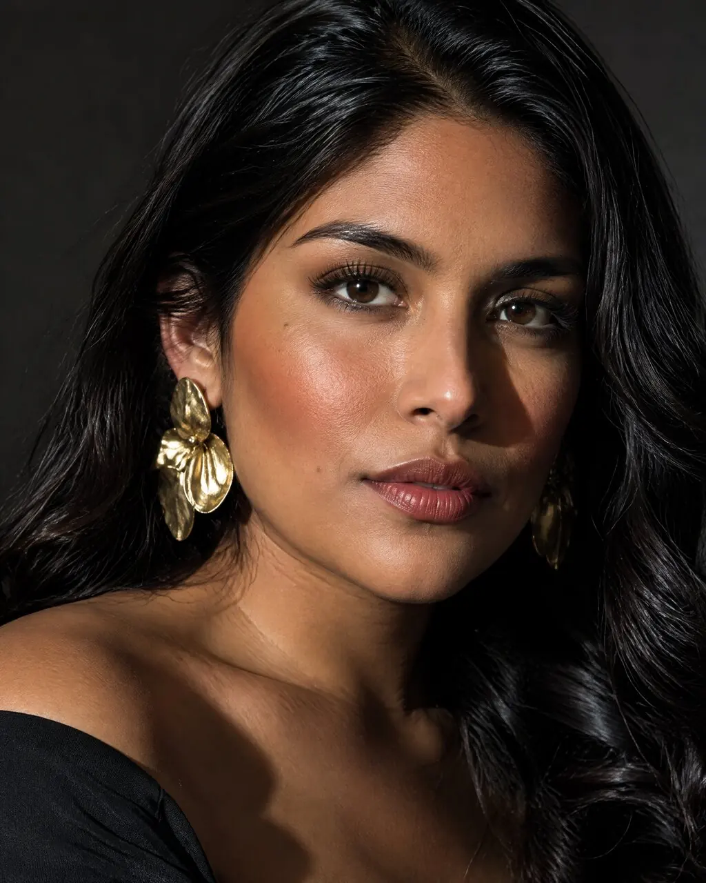 Foto estilo revista de mujer con aros dorados y mirada a cámara